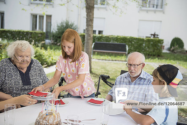 Familie deckt Tisch im Freien