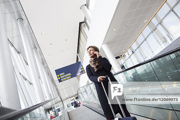 Eine Frau die auf ihrem Handy im Stockholmer Flughafen Arlanda telefoniert.