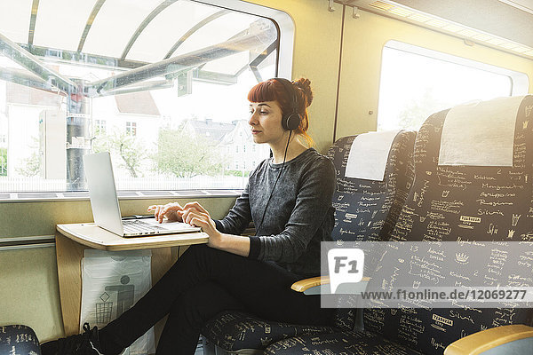 Frau mit Laptop im Zug