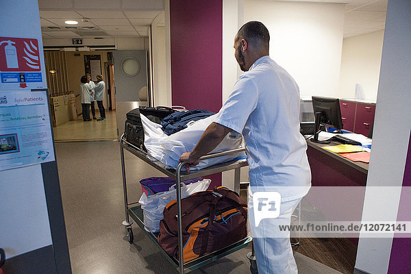 Reportage in the Léon Bérard cancer centre in Lyon  France. A hospital porter picks up luggage belonging to patients who will be hospitalized the same evening  dropping it off at their room.