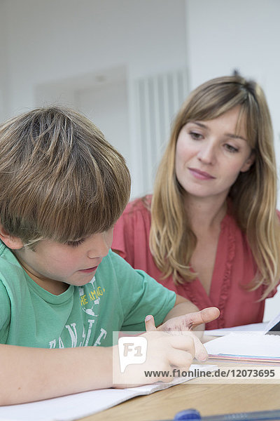 Ein Kind macht mit seiner Mutter Hausaufgaben.