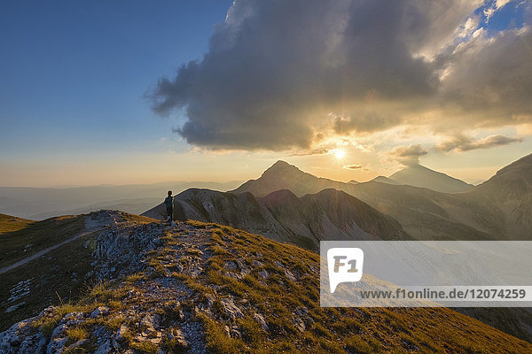 Hiker in front of mountain Portella at sunset  Gran Sasso e Monti della Laga National Park  Abruzzo  Italy  Europe
