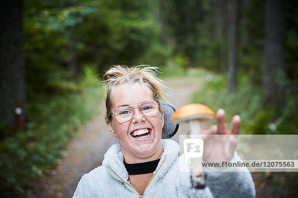 Porträt einer behinderten jungen Frau mit Pilz im Wald