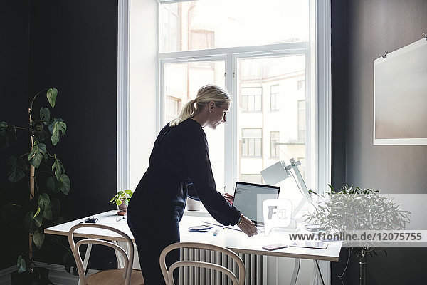 Geschäftsfrau mit Laptop auf dem Schreibtisch im Home-Office