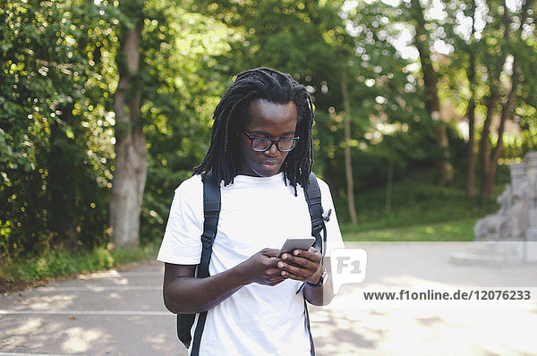 Young university student using mobile phone outside university