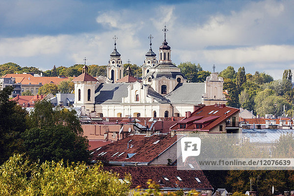 Litauen  Vilnius  Gewitterwolken über Kirche und Wohngebäuden