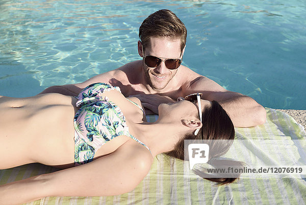 Close up of Caucasian couple relaxing at swimming pool