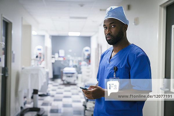Portrait of black nurse texting on cell phone