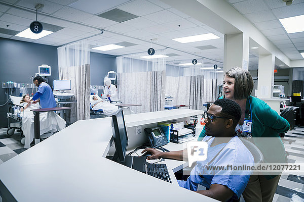 Arzt und Krankenschwester benutzen Computer im Krankenhaus