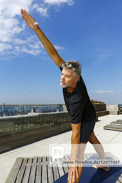 Caucasian man performing yoga on urban rooftop