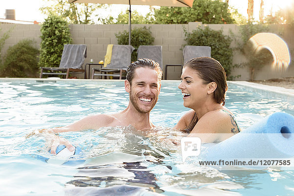 Lächelndes kaukasisches Paar entspannt sich im Schwimmbad