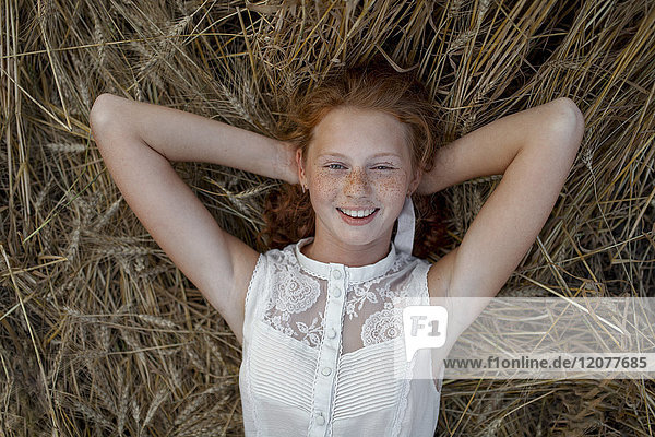 Caucasian girl laying in wheat