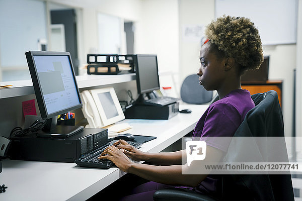 Black nurse using computer