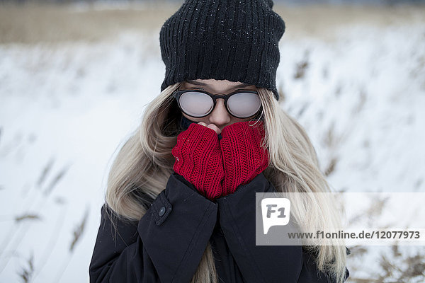Cold Asian girl wearing a hat and eyeglasses in winter