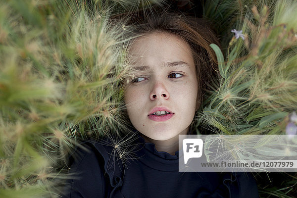 Concerned Caucasian girl laying in field