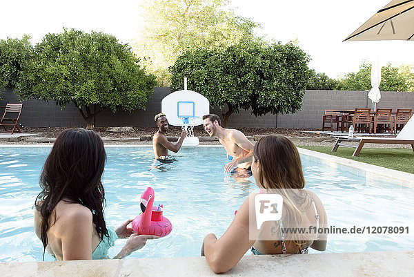 Frauen beobachten Männer beim Spielen im Schwimmbad