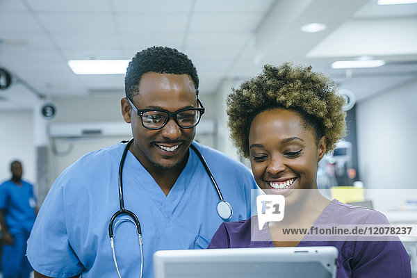 Lächelnde schwarze Krankenschwestern mit digitalem Tablet