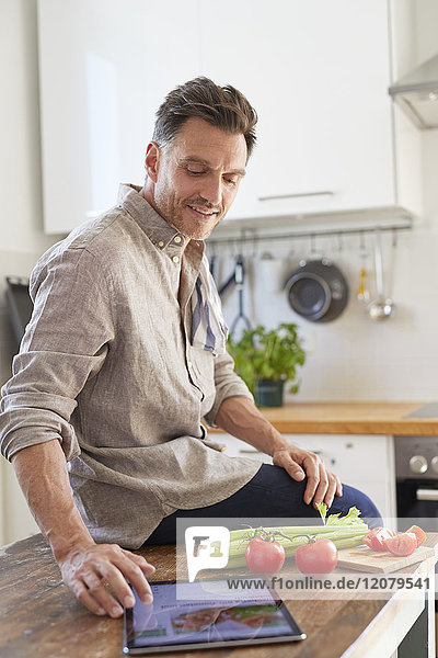 Porträt eines Mannes mit Tablette in der Küche