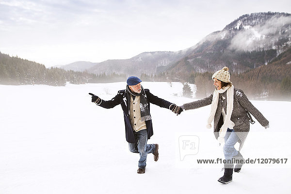 Seniorenpaar mit Spaß in verschneiter Landschaft