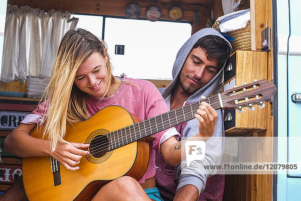 Junges Paar mit Gitarre im Transporter