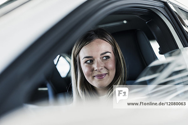 Lächelnde junge Frau im Auto