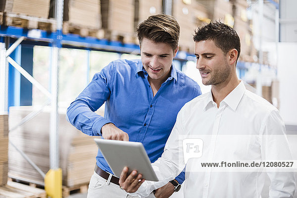 Two businessmen having a meeting in company warehouse