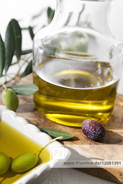 Frisches Olivenöl in Schale und Oliven