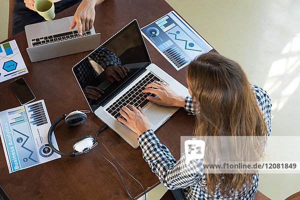 Junge Berufstätige die in einem Start-up-Unternehmen zusammenarbeiten und einen Businessplan entwickeln.