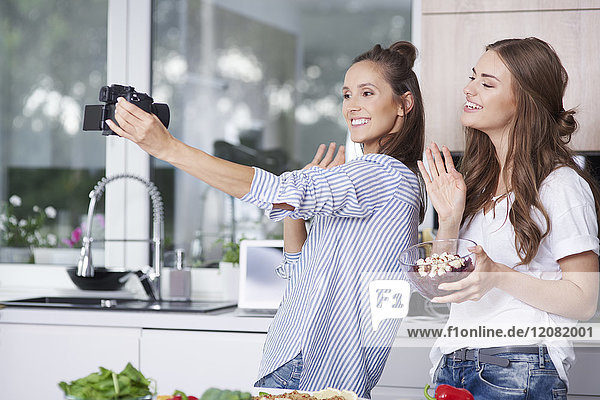 Food bloggers greeting their viewers in kitchen