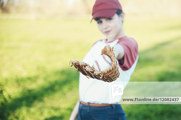 Portrait der jungen Frau mit Ball und Baseballhandschuh