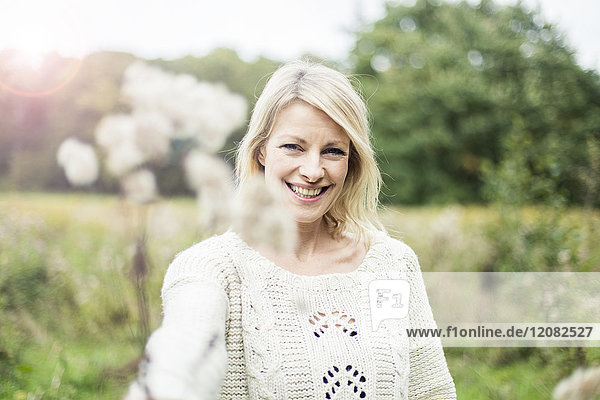 Porträt einer glücklichen blonden Frau im Freien