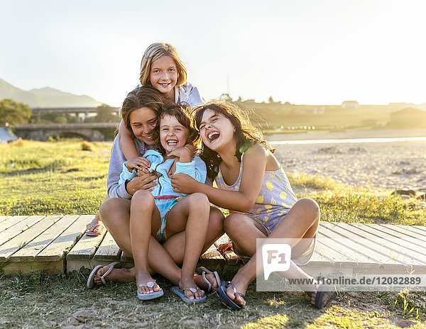 Gruppenfoto von vier Mädchen an der Strandpromenade mit Spaß