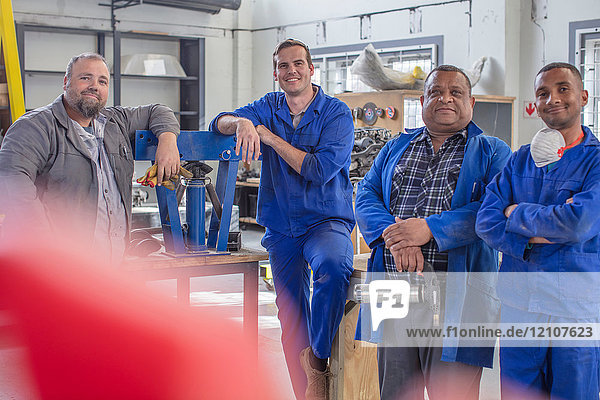 Portrait of male car mechanic team in repair garage