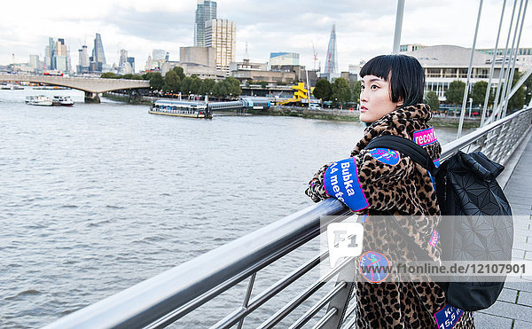 Stilvolle junge Frau  die von der Millennium-Fußgängerbrücke blickt  London  UK