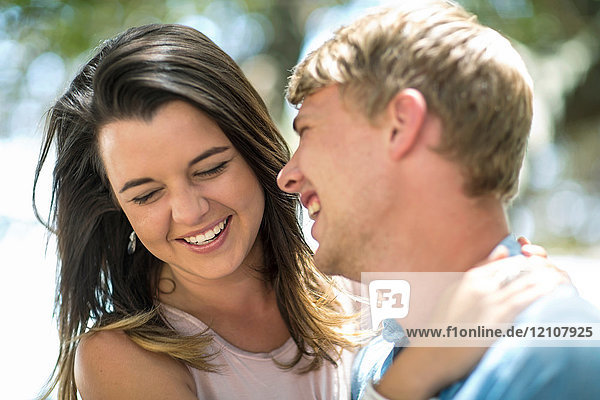 Glückliches junges Paar lacht am Strand