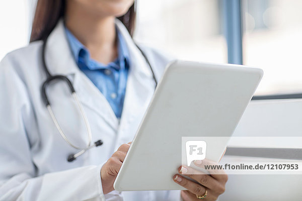 Ärztin mit digitalem Tablett  mittlerer Abschnitt