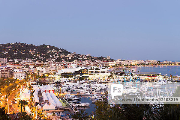 Stadtbild mit Hotels am Wasser und Yachthafen in der Abenddämmerung, Cannes, Côte d'Azur, Frankreich