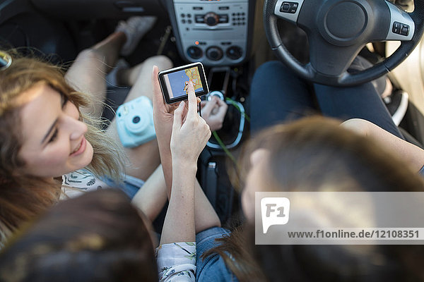 Three young women in car  looking at sat nav  overhead view