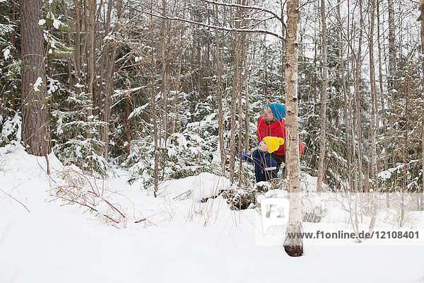 Man and son looking up from snow covered forest