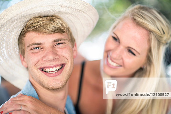 Junges Paar lacht gemeinsam bei Strandparty