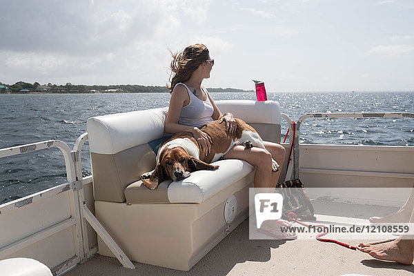 Woman and pet dog relaxing on boat