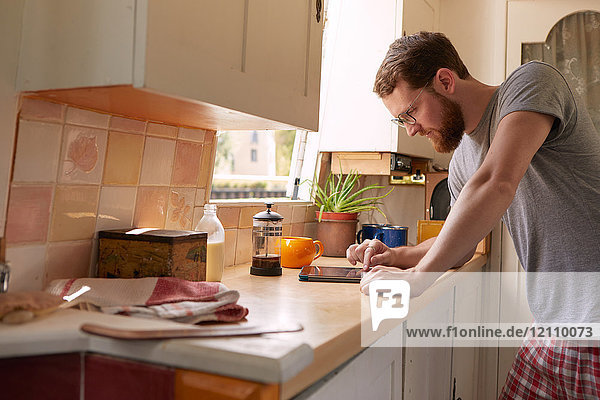 Mann in Kanalboot-Küche mit digitalem Tablett