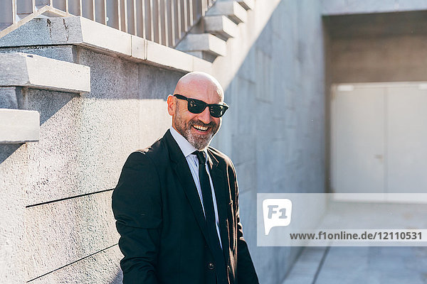 Porträt eines reifen Geschäftsmannes im Freien  neben der Treppe stehend  lächelnd