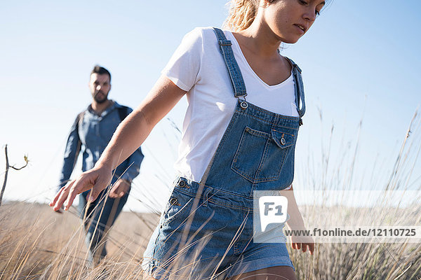 Junges Wanderpaar wandert durch langes Gras  Las Palmas  Kanarische Inseln  Spanien