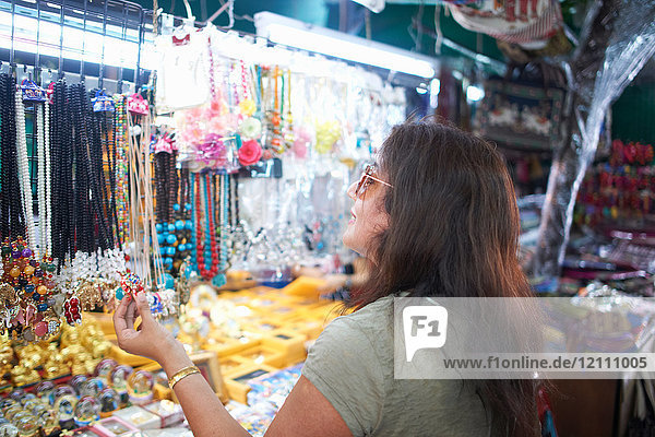 Frau betrachtet Souvenirs am Marktstand  Bangkok  Krung Thep  Thailand  Asien