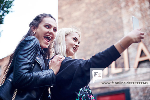 Zwei junge Frauen nehmen Smartphone-Selfie auf der Straße
