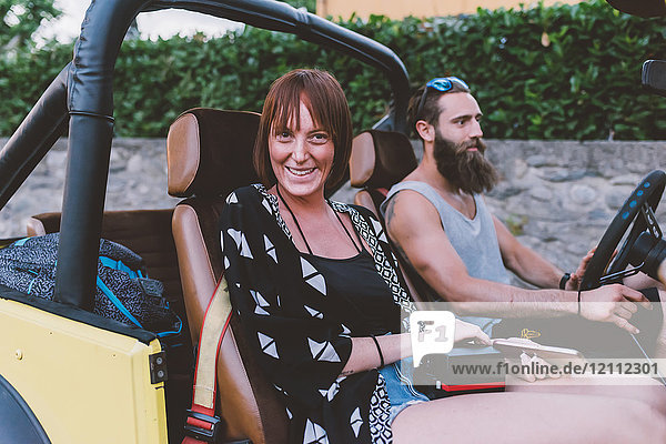 Portrait of young couple on road trip in off road vehicle  Como  Lombardy  Italy