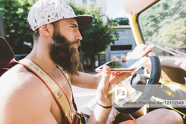 Young male hipster on road trip using smartphone navigation  Como  Lombardy  Italy