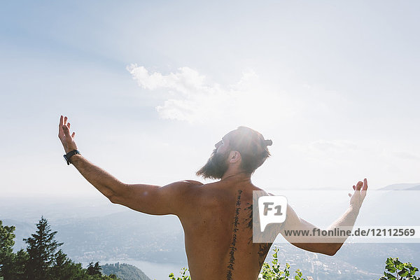 Young male hipster with arms open  Lake Como  Lombardy  Italy