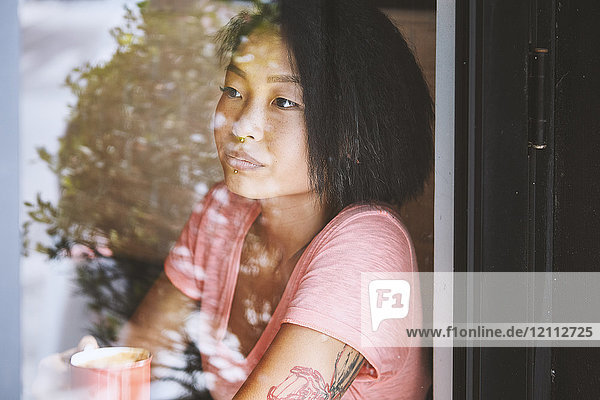 Frau blickt am Fensterplatz eines Cafés  Shanghai Französische Konzession  Shanghai  China